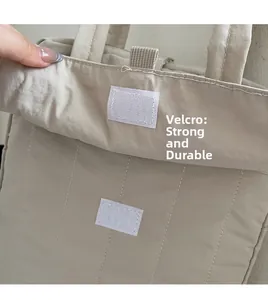 Detail view of the durable velcro closure and beige quilted fabric on this commute tote bag