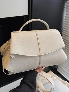 Fashionable beige textured leather handbag with gold metal accents and top handle