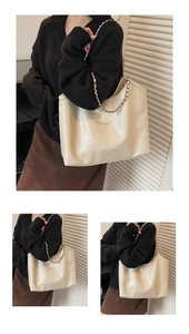 Detail of beige tote bag with soft leather texture and stylish gold chain shoulder strap
