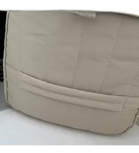 Dettaglio ravvicinato del tessuto trapuntato beige di una borsa porta computer