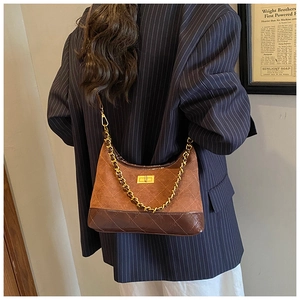Close-up of vintage quilted leather dumpling bag with metal chain strap and turn-lock