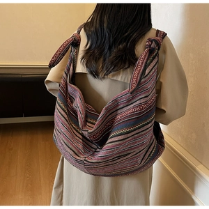 Detailed close-up of bohemian striped canvas tote bag with woven texture and knotted strap