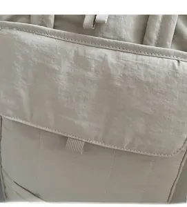 Detailed close-up of soft quilted nylon fabric and stitching on a large laptop bag
