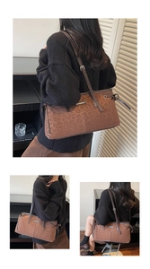 Detail view of large brown animal print shoulder bag with metallic branding and stitching