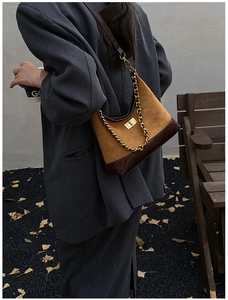 Detail view of vintage quilted leather patchwork handbag with gold chain and turn-lock
