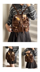 Detail view of vintage dark brown faux leather backpack with plush charms and buckles