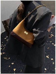 Close-up of vintage brown quilted leather bag with gold metal twist lock and chain strap