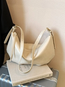 Minimalist beige half-moon tote bag with pleated design and adjustable straps