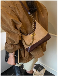Close-up of vintage quilted hobo bag with gold chain and brown suede patchwork detail