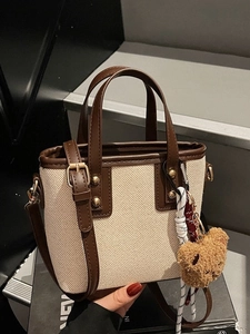 Contrast canvas and leather bucket bag with plush bear charm and crossbody strap