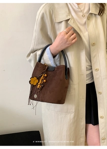 Details der braunen Wildleder-Eimertasche mit ethnischen Perlen und Quastenanhänger