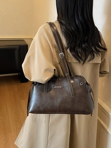Retro dark brown PU leather tote bag with Sunny Day label worn with a beige trench coat