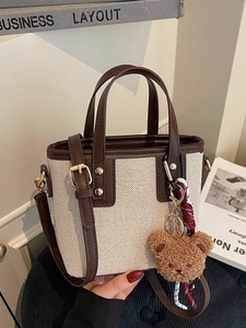 Contrast trim canvas bucket bag with brown leather handles and a cute bear charm