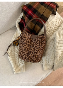 Detailansicht der Beuteltasche mit Leopardenmuster, Ledergriff und Blumenanhänger