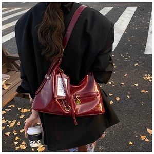 Detail of burgundy glossy leather hobo bag with front zip pocket and card holder accessory