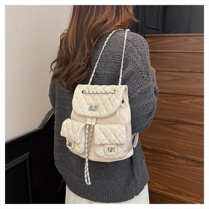 Gesteppter cremefarbener Rucksack mit Silber-Drehverschluss und Kettenriemen am Model