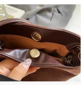 Gros plan de l'intérieur du sac seau en daim avec fermoir magnétique et dorure chic
