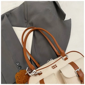 Detail of vintage pillow bag with canvas material, leather trim and bear pendant charm