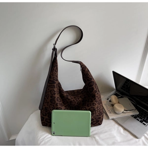 Detailed view of large leopard print tote bag interior capacity with a tablet for scale