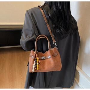 Borsa a tracolla in pelle scamosciata marrone con ciondolo in legno e chiusura a vite