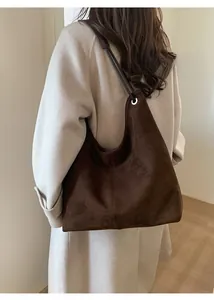 Detail showing the drape and large capacity of the brown suede hobo bag on model