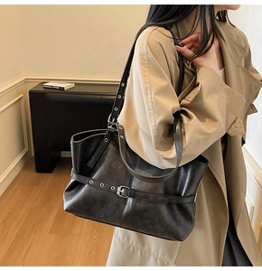 Vue détaillée du sac cabas en cuir noir rétro avec ceinture à boucle et œillets métalliques