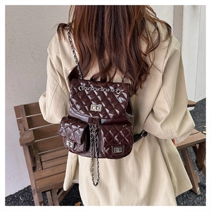 Detail eines gesteppten braunen Lederrucksacks mit Kettenriemen und Drehverschluss-Taschen
