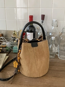 Vintage-Eimertasche aus khakifarbenem Wildleder mit runden Griffen und Blumenanhänger