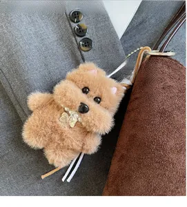 Détail du charm caniche en peluche marron avec collier de perles et plaque en métal