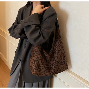 Close-up of leopard print tote bag on shoulder showing large capacity and stylish texture