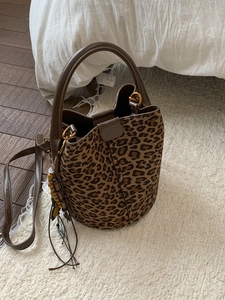 Vintage-Beuteltasche mit Leopardenmuster, Ledergriffen und dekorativem Quastenanhänger