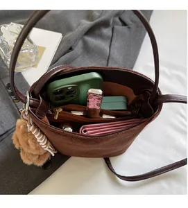 Intérieur spacieux du sac seau en daim marron montrant sa grande capacité de rangement