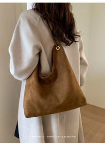 Detail view of large retro brown suede hobo bag with minimalist metal eyelet design