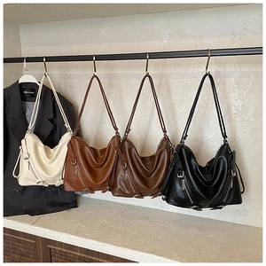 Close-up of retro biker style tote bags in four colors with decorative side zippers