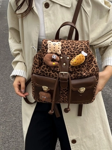 Fashionable leopard print backpack with brown leather trim and cute plush patches