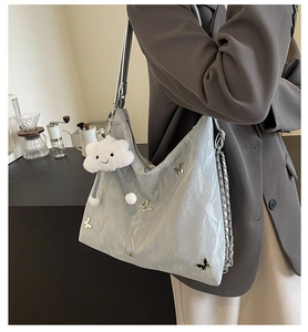 Light gray pleated hobo bag with silver butterfly charm and plush cloud keychain
