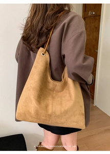 Close-up of a minimalist camel suede hobo bag showing its vintage texture and design