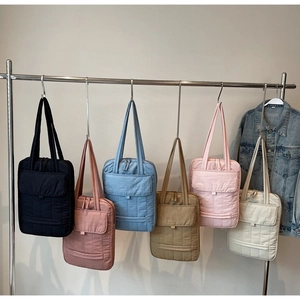 Close-up of quilted laptop bags in six colors hanging on a rack for commute style
