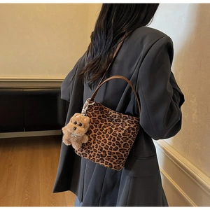 Gros plan du sac à bandoulière léopard avec pendentif ours en peluche sur un modèle