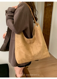Detailed side view of a large brown retro tote bag with minimalist shoulder strap design
