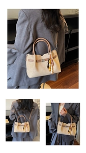Detalle de bolso tote de ante retro con adornos de cuero marrón y un colgante de cuentas de color