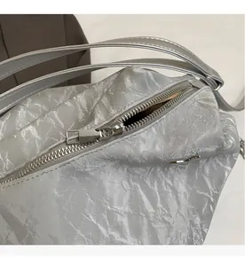 Close-up of smooth silver metal zipper and wrinkled texture on the large shoulder bag