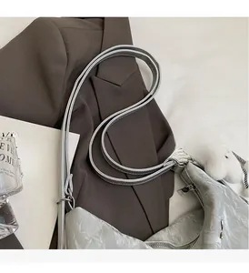 Macro detail of silver metallic leather bag with crinkled texture and plush white charm