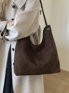 Large dark brown suede bucket tote bag shown on model for elegant daily commuting