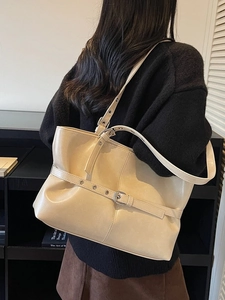 Sac fourre-tout chic en cuir beige avec boucle et bandoulière réglable sur le mannequin