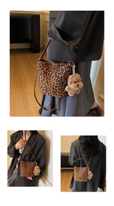 Détail d'un sac seau léopard avec breloque chien en peluche et bandoulière amovible