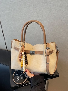 Borsa tote minimalista in pelle scamosciata beige con manici marroni e nappa