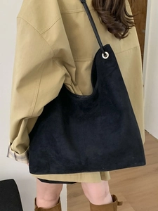 Large black suede bucket tote bag with minimalist design and silver metal hardware details