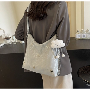 Silver metallic crossbody bag with butterfly charms and a plush cloud accessory