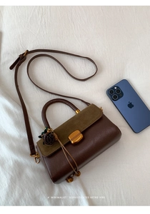Detail of retro leather and green suede stitching bag with golden twist lock hardware